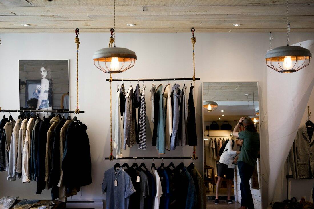 Interior da loja com roupa em cabides